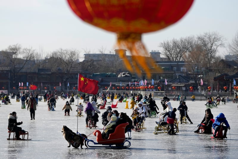 Chinese lantern hanging while residents enjoy skating on the frozen Houhai Lake in Beijing.