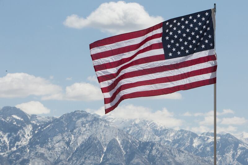 An American flag flies over a crowd of demonstrators during a pro-gun rally on the steps of the Utah Capitol on Saturday, April 14, 2018, in Salt Lake City. At the protest, demonstrators heard from numerous speakers airing their beliefs about firearms, gu