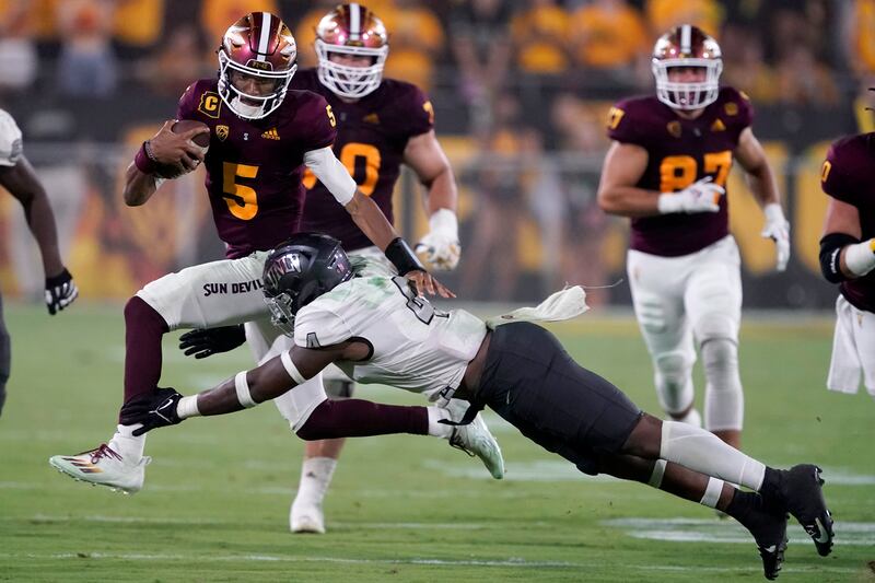 Arizona State quarterback Jayden Daniels avoids the tackle of UNLV player during game Sept. 11, 2021, in Tempe, Ariz.