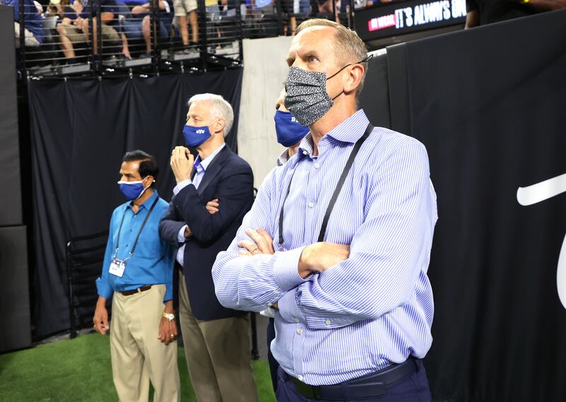 Brigham Young Cougars athletic director Tom Holmoe, wearing a mask, watches a game.