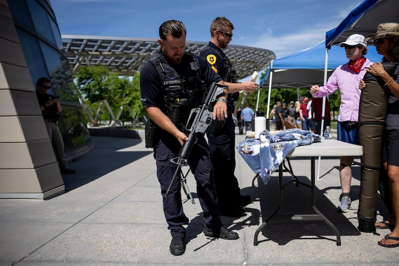 Salt Lake City police officer Greenfield inspects a rifle being turned in at a voluntary gun buyback program.