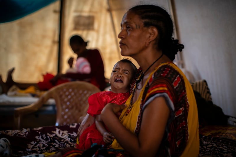 Roman Kidanemariam holds her malnourished daughter in the town of Abi Adi in the Tigray region of Ethiopia on May 11, 2021.