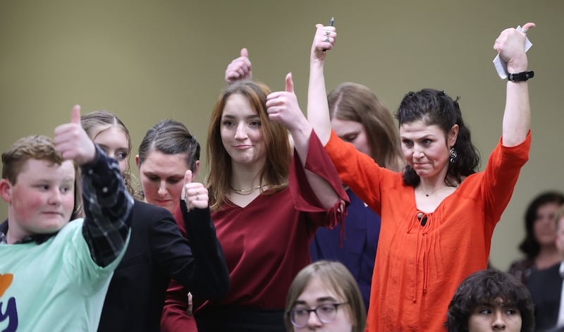 Elissa Ludlum and others give a thumbs-up after hearing a public comment at a House Education Committee hearing.