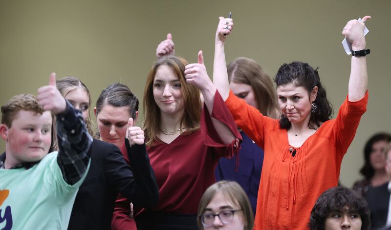 Elissa Ludlum and others give a thumbs-up after hearing a public comment at a House Education Committee hearing.