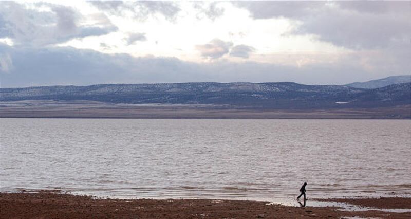 Gregory Wing of Spanish Fork walks along the shoreline of Utah Lake near Lincoln Beach as a storm breaks.
