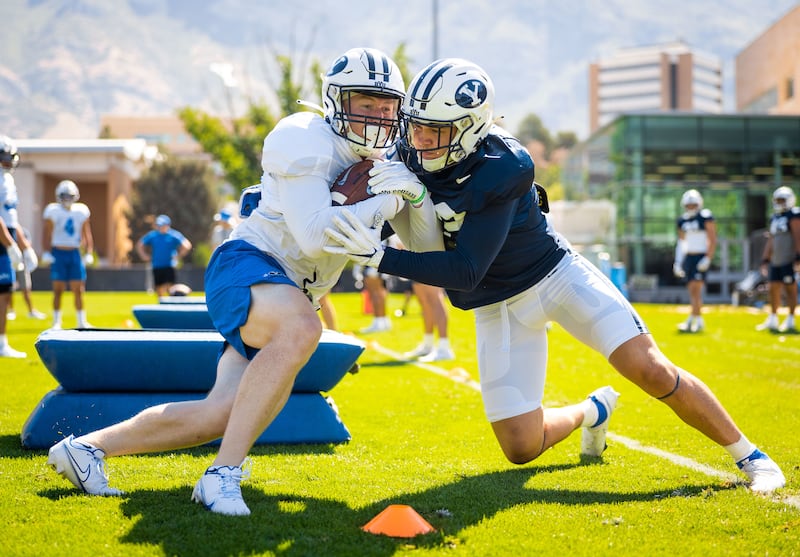 BYU linebacker Payton Wilgar, right, goes through drills during BYU practice on Tuesday, Aug. 9, 2022.