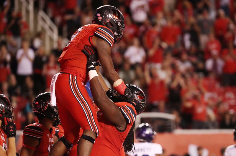 Utah running back Tavion Thomas celebrates his touchdown with offensive lineman Bamidele Olaseni in Salt Lake City.