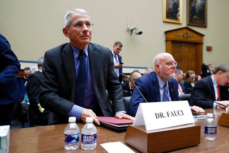 Dr. Anthony Fauci, left, director of the National Institute of Allergy and Infectious Diseases, departs during a recess after testifying before a House Oversight Committee hearing on preparedness for and response to the coronavirus outbreak on Capitol Hill in Washington, Wednesday, March 11, 2020.