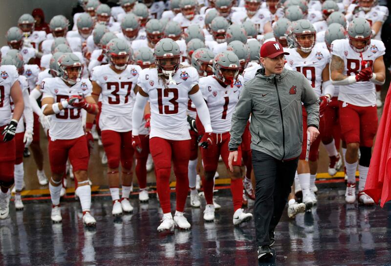 Washington State coach Jake Dickert leads team onto the field in the Sun Bowl in El Paso, Texas, Friday, Dec. 31, 2021.