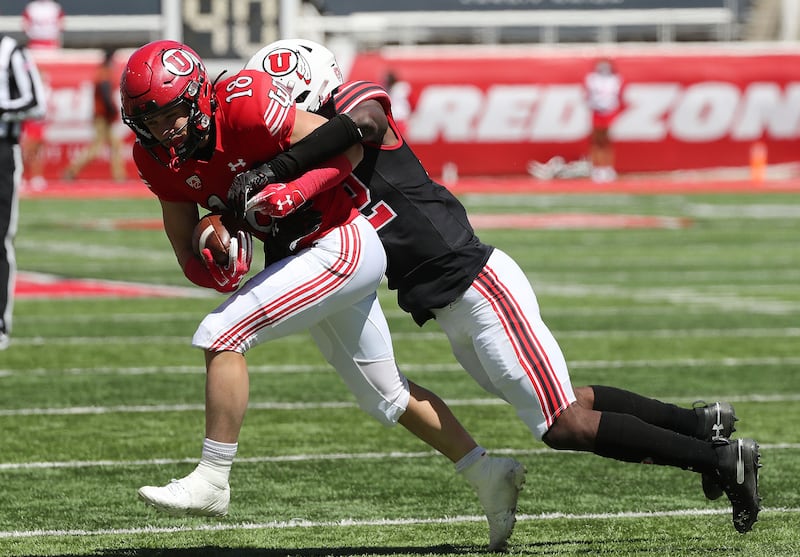 Utah defensive back Aaron Lowe tackles receiver Britain Covey during spring game in Salt Lake City on April 17, 2021.