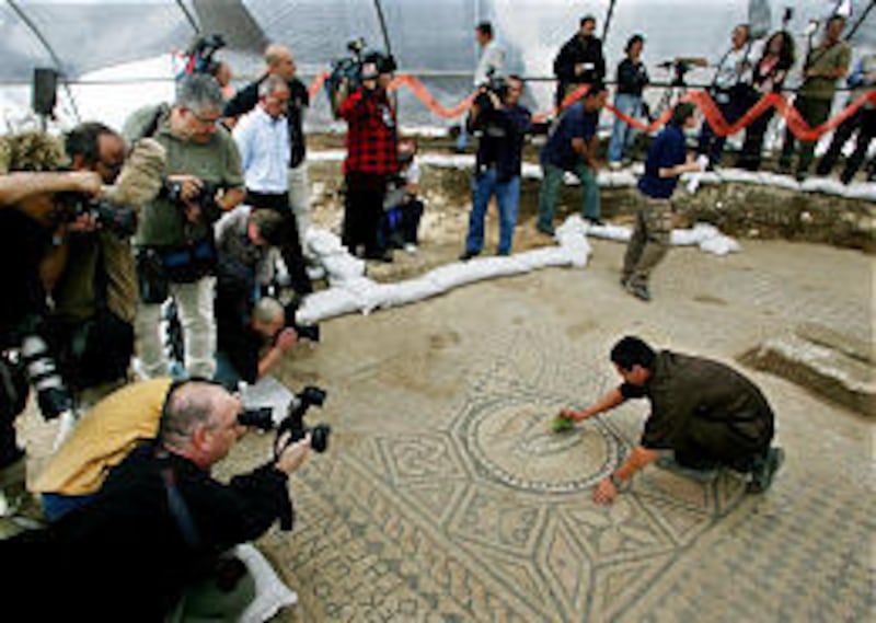 Surrounded by journalists, Israeli prisoner Ramil Razilo, right, cleans a section of a Christian mosaic floor in the Megiddo Prison.