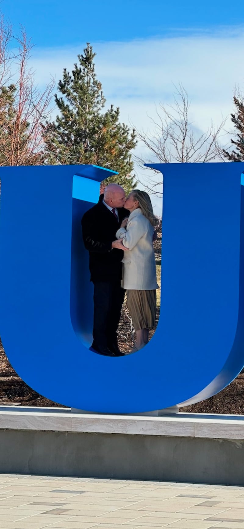 BYU-Idaho President Alvin Meredith III and his wife Jennifer kiss in the school's block-letter BYUI monument.