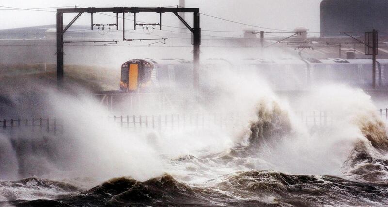 A train makes its way through strong winds as high waves batter the shore near Saltcoats, North Ayrshire, Scotland, as the remnants of Hurricane Katia hit British shores, Monday Sept. 12, 2011. Britain's weather agency says the tail end of former Hurrican