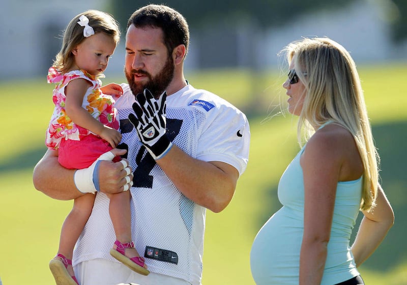 Carolina Panthers' Ryan Kalil, center, greets his daughter Kenadi, 20 months, left, as his wife Natalie Kalil, right, watches before practice at the NFL team's football training camp in Spartanburg, S.C., Sunday, July 29, 2012.