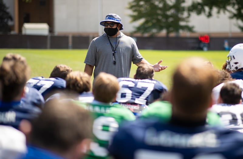 BYU Cougars football coach Kalani Sitake talks with his players after a football practice in 2020.