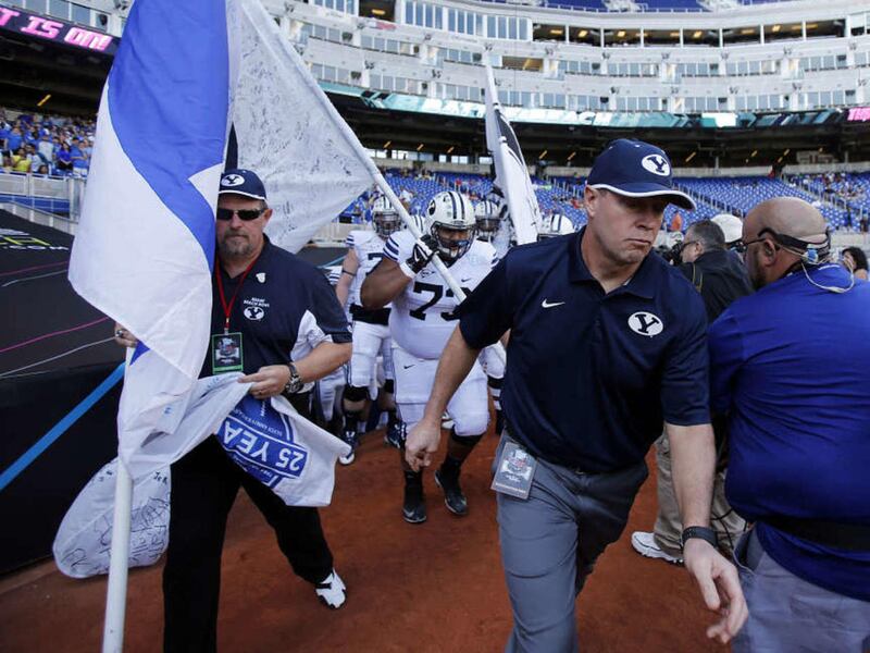 Head Coach Bronco Mendenhall of Brigham Young leads his team onto the field to play against Memphis in the Miami Beach Bowl, Monday, Dec. 22, 2014.