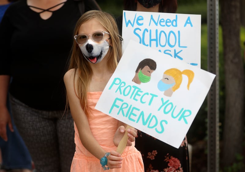 Torah Neil, 10, holds a sign in support of school mask mandates in Salt Lake City.