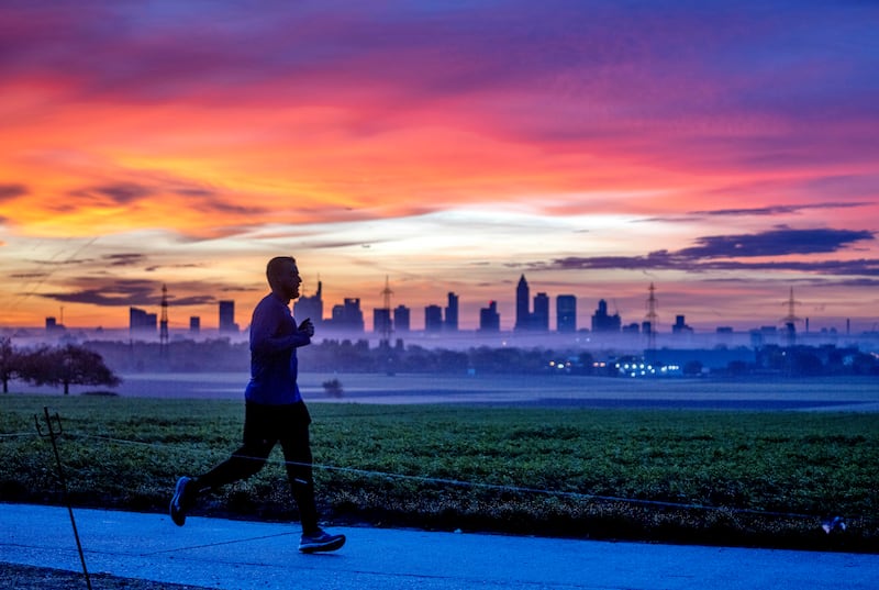 The buildings of the banking district are pictured in Frankfurt, Germany, as a man jogs by before sunrise.