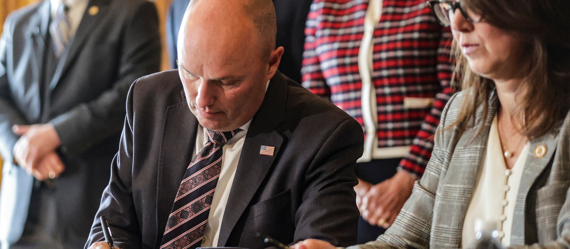 Gov. Spencer Cox, left, and Utah Lt. Gov. Deidre Henderson ceremonially sign bills focused on law enforcement and mental health issues.