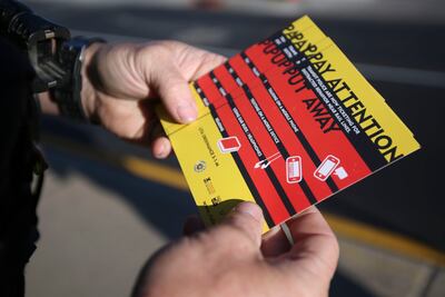 A Utah Transit Authority police officer holds a stack of railroad safety cards to hand out to motorists and pedestrians for “Operation Clear Track” as part of Rail Safety Week in Salt Lake City on Tuesday, Sept. 25, 2018.