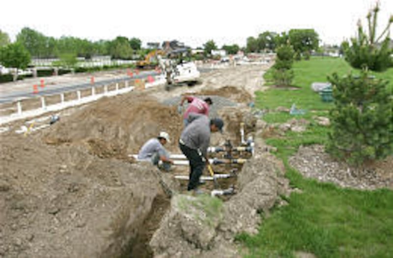 Jose Rodriguez, left, Francisco Reyes, front, and Jose Antonio Rodriguez work on sprinklers on the west side of Nielsen's Grove Park.