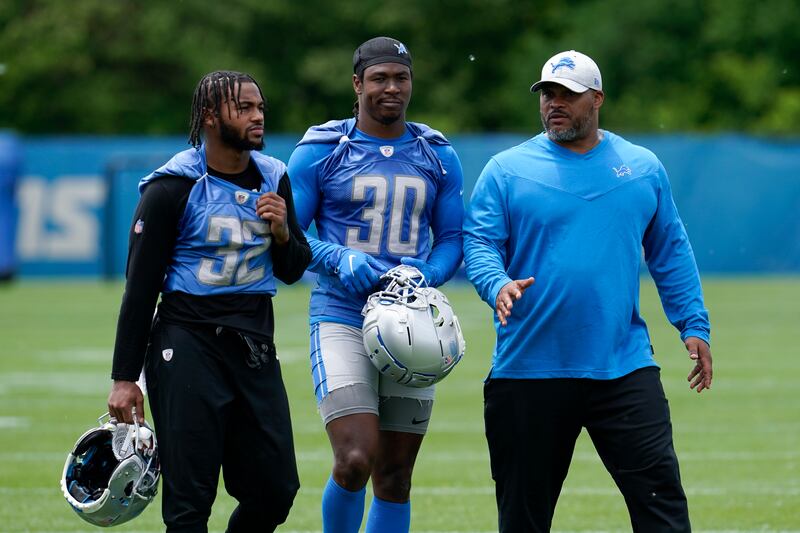 Detroit Lions running backs D’Andre Swift (32) and Jamaal Williams (30) talk with assistant head coach and running backs coach Duce Staley.