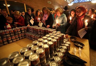 People take charity boxes to collect money for those in need on their way out of a vigil and prayer service for all those impacted by the shooting at the Tree of Life Synagogue in Pittsburgh, at Chabad Lubavitch of Utah in Salt Lake City on Monday, Oct. 2