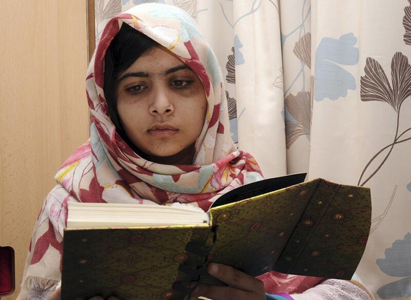 FILE - In this undated file photo provided by Queen Elizabeth Hospital in Birmingham, England, Malala Yousufzai, the 15-year-old girl who was shot at close range in the head by a Taliban gunman in Pakistan, reads a book as she continues her recovery at th