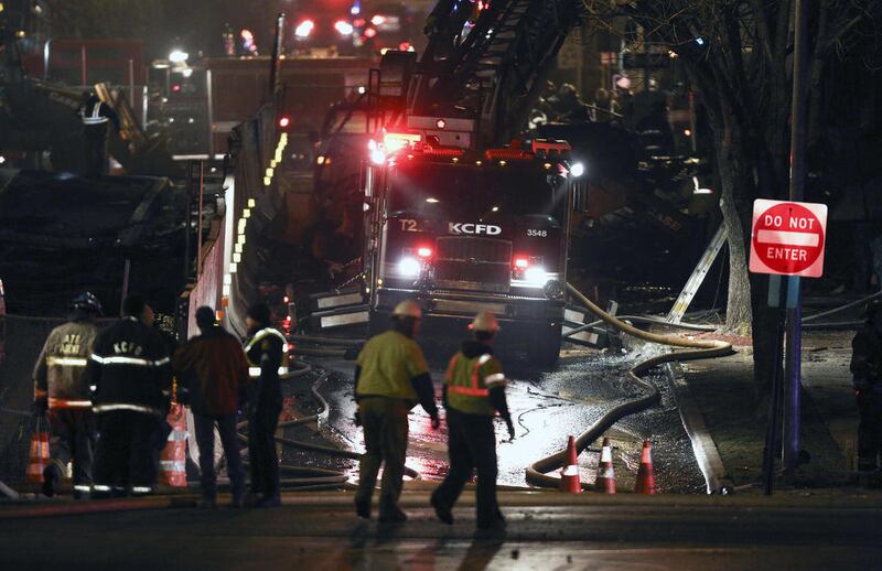 Firemen and utility workers respond to a gas explosion and massive fire Tuesday night, Feb. 19, 2013 in the Plaza shopping district in Kansas City, Mo. A car crashed into a gas main in the upscale shopping district, sparking a massive blaze that engulfed
