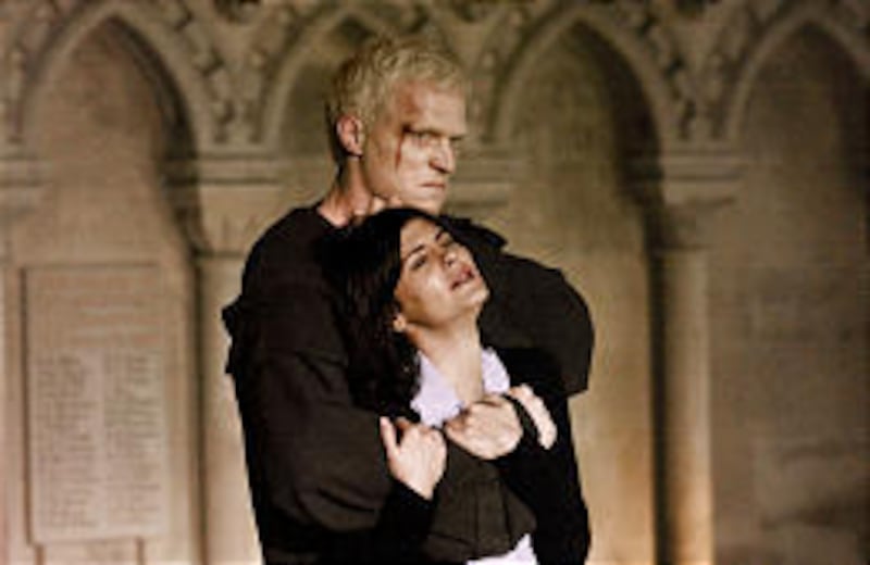 Paul Bettany as an albino murderer restrains Audrey Tautou in "The Da Vinci Code."