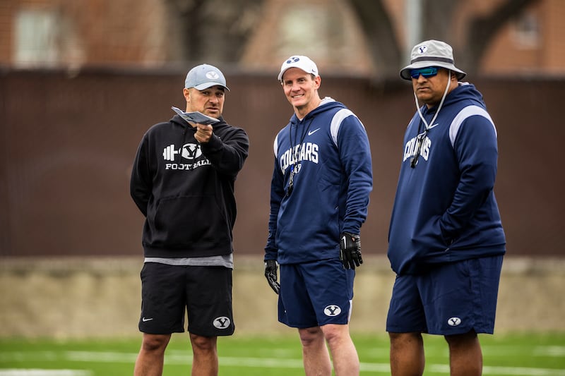 BYU passing game coordinator and wide receivers coach Fesi Sitake, talks with defensive coordinator Jay Hill and head coach Kalani Sitake during practice.