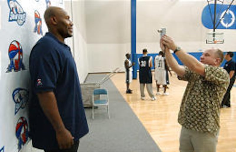 Snowbears owner and coach Ike Austin endures a photo-op during media-day events Wednesday.
