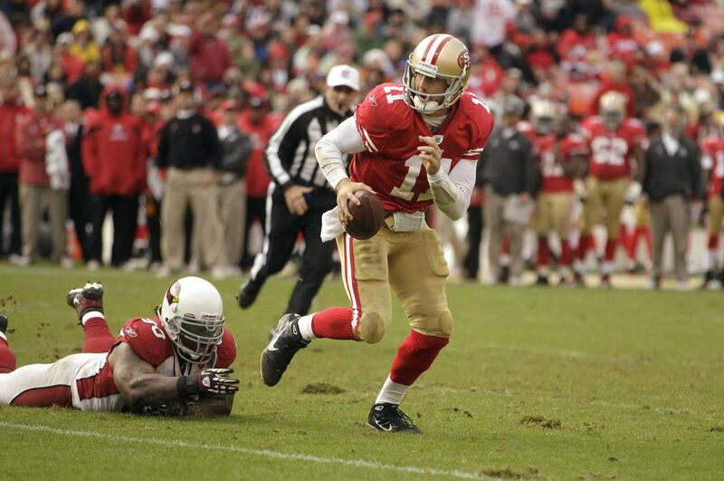 San Francisco 49ers quarterback Alex Smith (11) scrambles as Arizona Cardinals defensive end Darnell Dockett (90) reaches for him in the fourth quarter of an NFL football game in San Francisco, Calif., Sunday, Nov. 20, 2011. (AP Photo/Ben Margot)