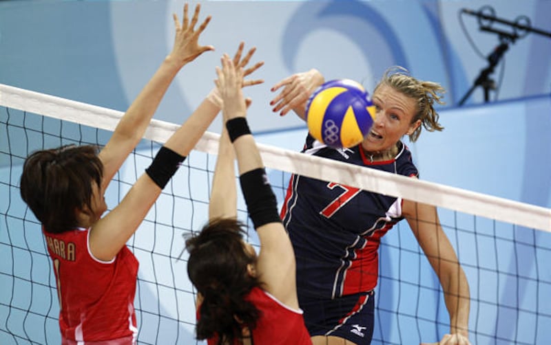 American Heather Bown spikes the ball against Japan's Megumi Kurihara, left, and Erika Araki en route to a U.S. victory.