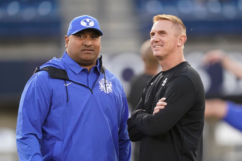 BYU head coach Kalani Sitake, left, and Utah State head coach Blake Anderson speak before an NCAA college football game.