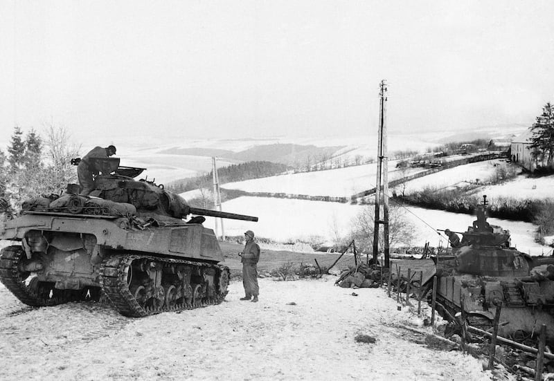 In this Jan. 6, 1945, file photo, American tanks wait on the snowy slopes in Bastogne, Belgium.