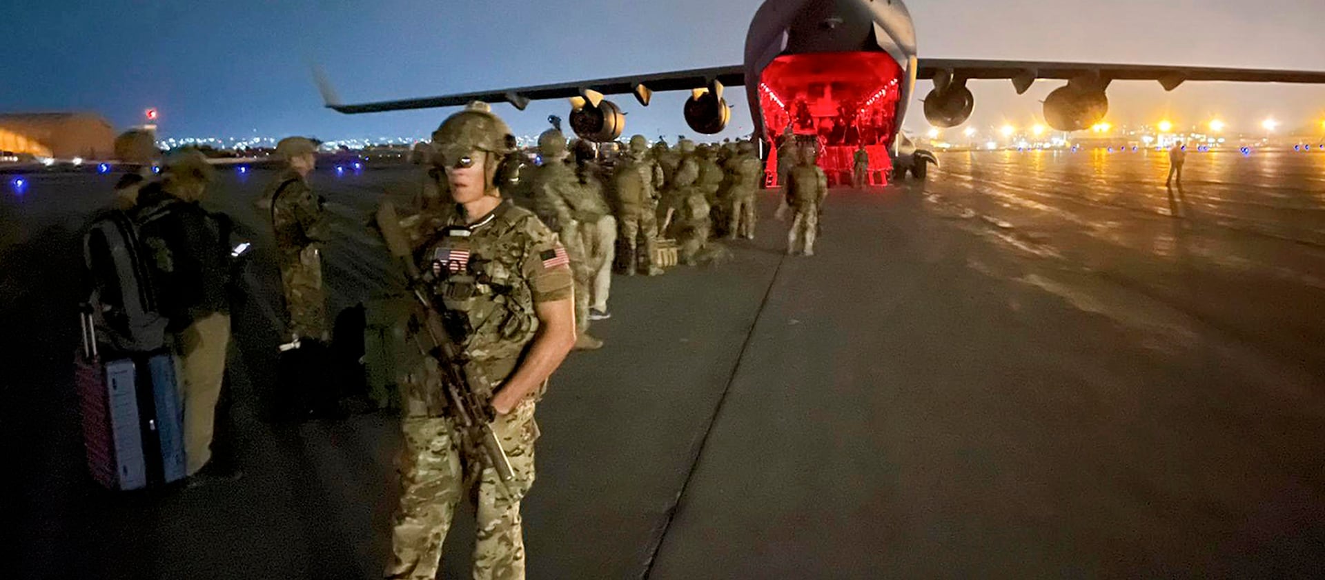 Paratroopers assigned to the 82nd Airborne Division, and others, prepare to board a C-17 cargo plane in Kabul, Afghanistan.