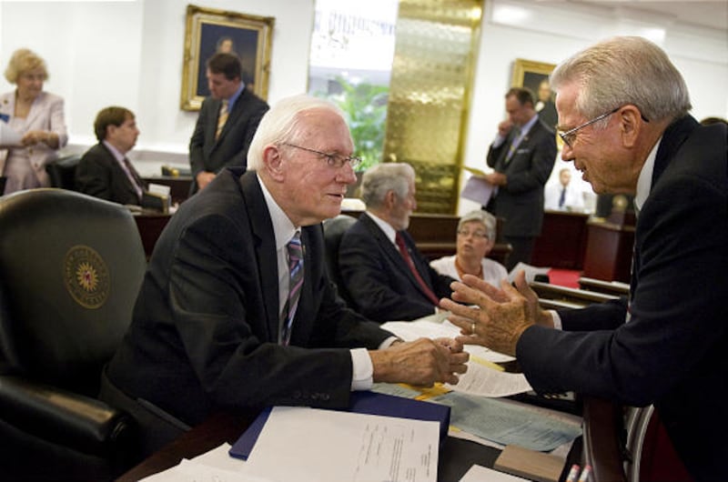 FILE - In a July 8, 2010 file photo Sen, R. C. Soles, Jr., left, and Sen. Jim Jacumin, right, talk during a break in their session in Raleigh, N.C.