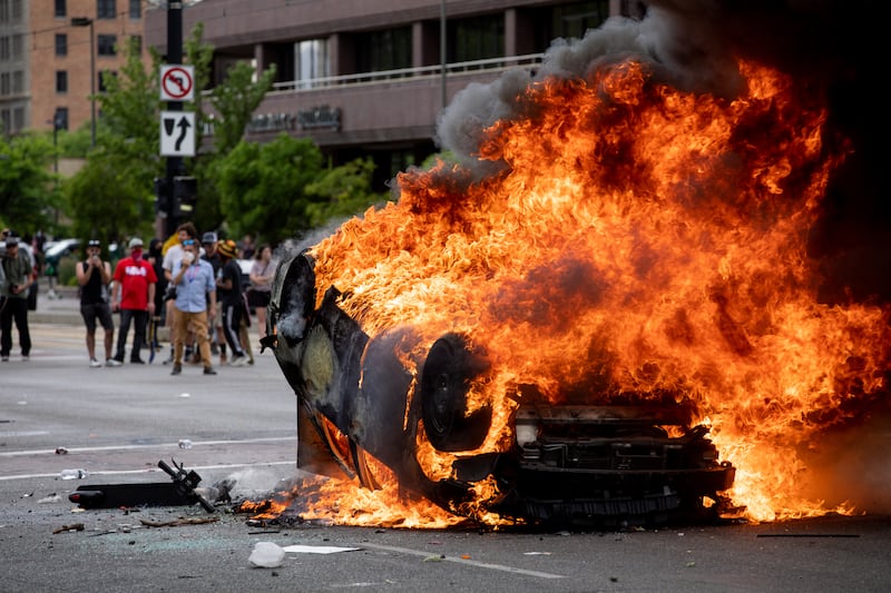 A police car is engulfed in flames as people protest police brutality in Salt Lake City on Saturday, May 30, 2020. Protesters joined others across the nation to decry the death of George Floyd, a black man , who died while being taken into custody by police in Minneapolis earlier this week. Video showed an officer kneeling on his neck while he implored, “I can’t breathe.”