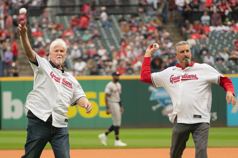 Former Cleveland Indians Cory Snyder, left, and Dave Burba, right, throw out the ceremonial first pitches before the Cleveland Guardians and the Houston Astros play a baseball game in Cleveland, Saturday, Sept. 28, 2024.