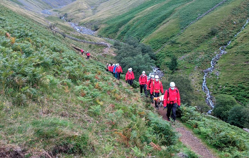 Volunteers from Wasdale mountain rescue team take turns to carry 121lb (55kg) St Bernard dog, Daisy from England’s highest peak, Scafell Pike, Sunday July 26, 2020.