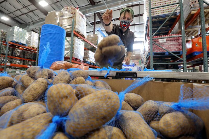 Volunteer Andrew Franks bags potatoes at Catholic Community Services, which will be distributed to those in need this Thanksgiving.