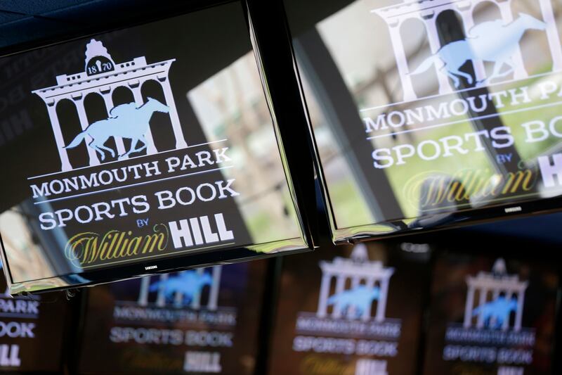 Signs for Monmouth Park are displayed in a bar at the racetrack in Oceanport, N.J., Monday, May 14, 2018. The Supreme Court on Monday gave its go-ahead for states to allow gambling on sports across the nation, striking down a federal law that barred betti