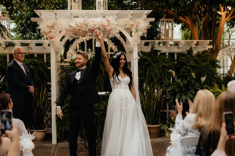 Austin and Larisset Cameron hold hands as newlyweds on their wedding day in Sandy, Utah.