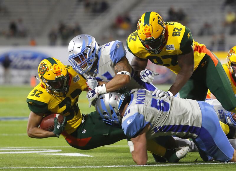 The Stallions' Cody Brown (21) and Greer Martini (51) tackle Arizona Hotshots running back Larry Rose III (32) during the first half at Sun Devil Stadium in Tempe, Ariz., on Sunday, Feb. 10, 2019.