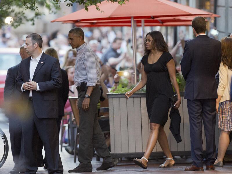 President Barack Obama leaves a Mexican restaurant owned by Chef Jose Andres, in downtown Washington on Saturday, May 30, 2015, with first lady Michelle Obama, second from right, and daughter Malia.