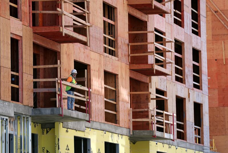 A worker stands on a balcony at a construction site in Salt Lake City.