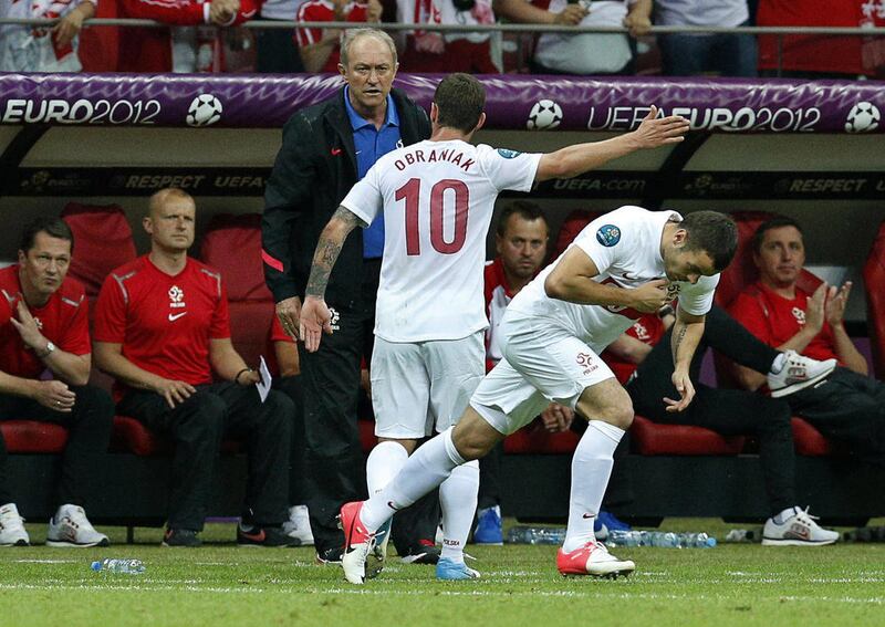 Poland's Ludovic Obraniak, center, gestures to Poland head coach Franciszek Smuda after being replaced by Pawel Brozek during the Euro 2012 soccer championship Group A match between Poland and Russia in Warsaw, Poland, Tuesday, June 12, 2012.