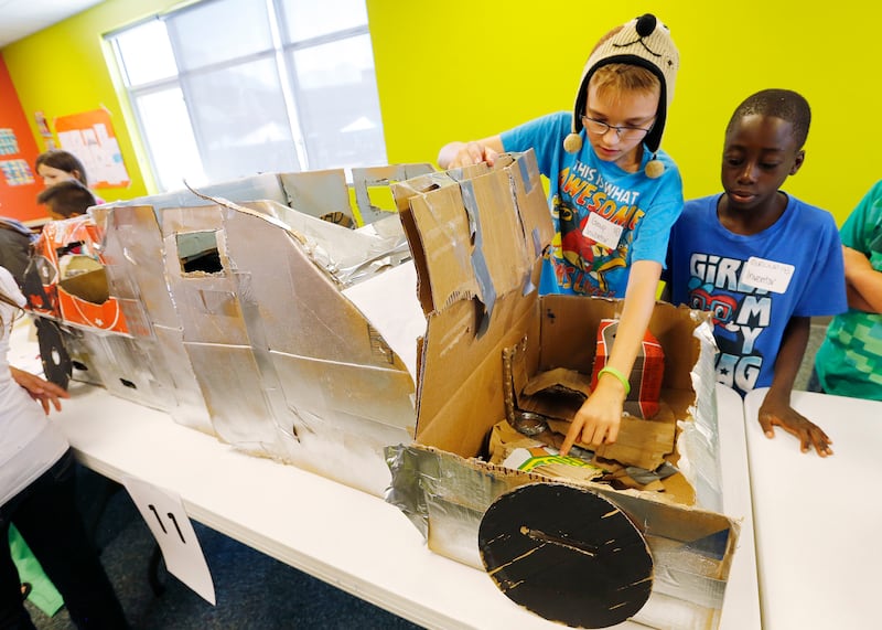 Alex Erickson and Emmanuel Kwewon show their car as YMCA campers create inventions in Ogden.
