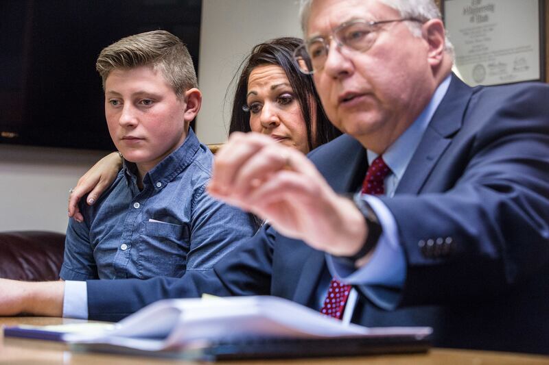 Greg, 14, left, and his mother, Misty Cox, listen to attorney Robert B. Sykes during a press conference in Salt Lake City on Thursday, Oct. 18, 2018. Greg, who says he was sexually assaulted by three football players from Gunnison Valley High School, has